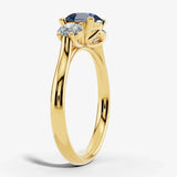 "Bluzz" Round Cut 1.5 Carat Blue Sapphire Trilogy Yellow Gold Engagement Ring Render- Side View
